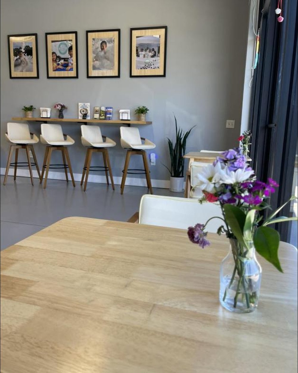 Inside KFAM Sweets in Goodlettsville, TN — bright, modern seating area with a wooden counter and fresh flowers